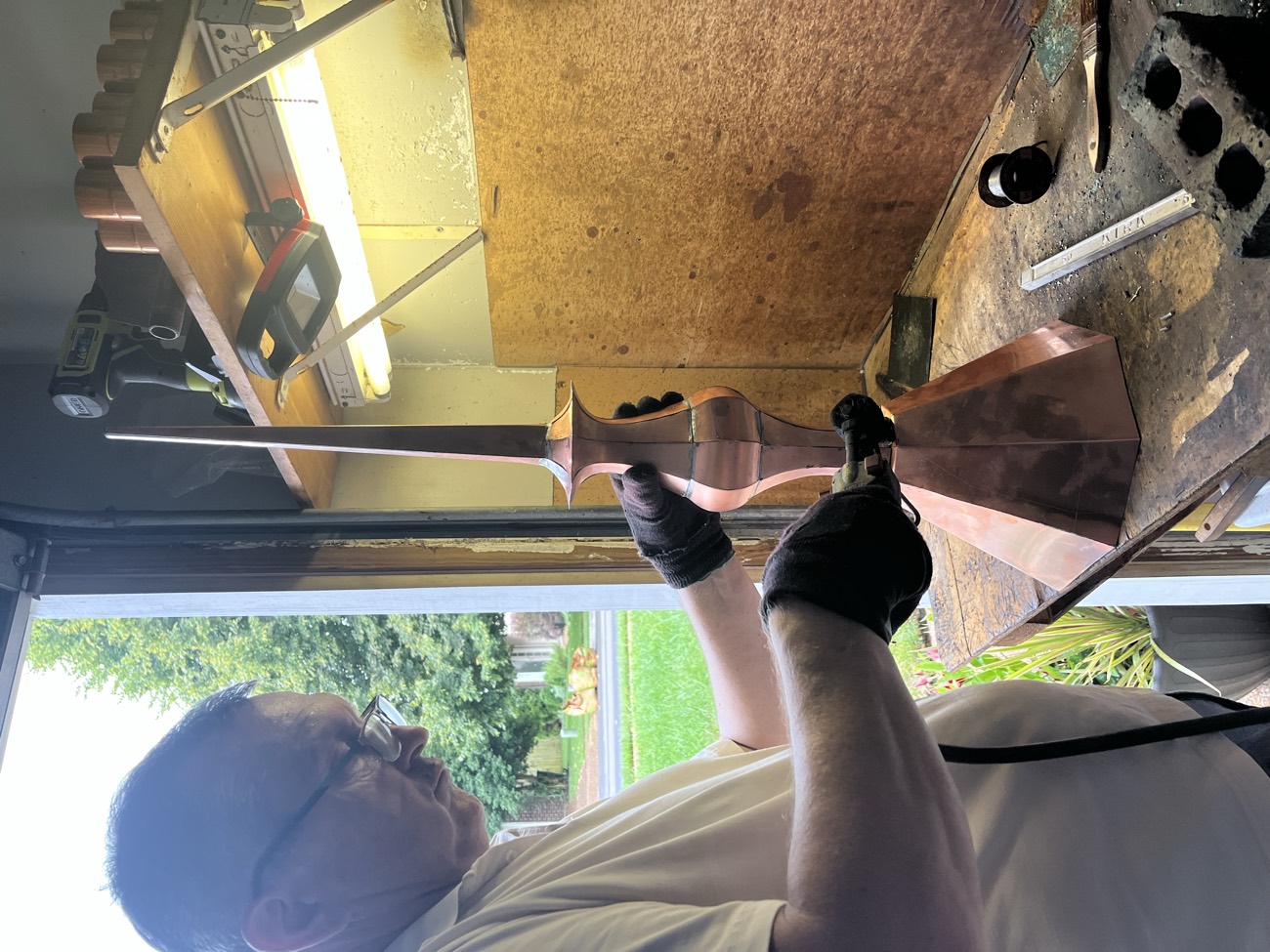 Sergei hand-forming a tall copper finial spire by hand